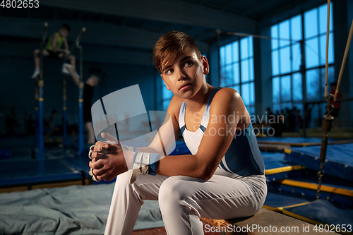 Image of Little male gymnast training in gym, flexible and active