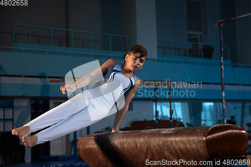 Image of Little male gymnast training in gym, flexible and active