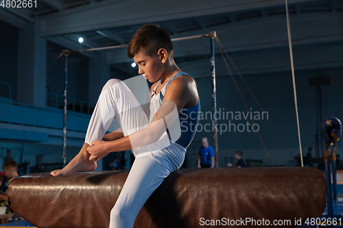 Image of Little male gymnast training in gym, flexible and active