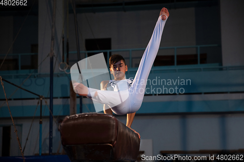 Image of Little male gymnast training in gym, flexible and active