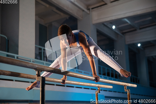 Image of Little male gymnast training in gym, flexible and active