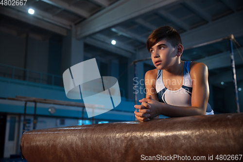 Image of Little male gymnast training in gym, flexible and active