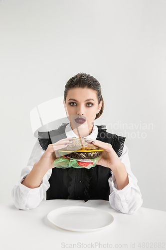 Image of We are what we eat. Woman\'s eating plastic food, eco concept