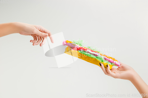 Image of We are what we eat. Close up of female hand with plastic food, eco concept