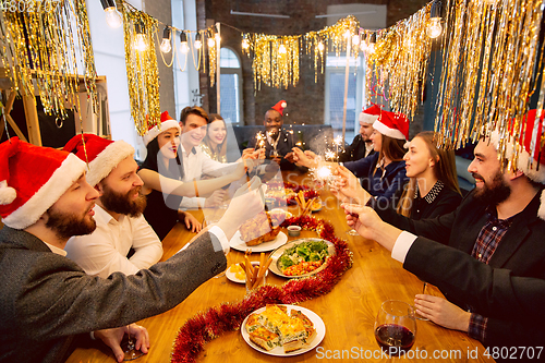 Image of Happy co-workers celebrating while company party for New Year and Christmas