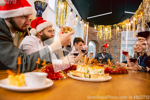 Image of Happy co-workers celebrating while company party for New Year and Christmas