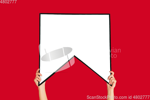 Image of Hands holding the sign of bookmark on red studio background