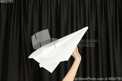 Image of Hands holding the sign of paper airplane on studio background