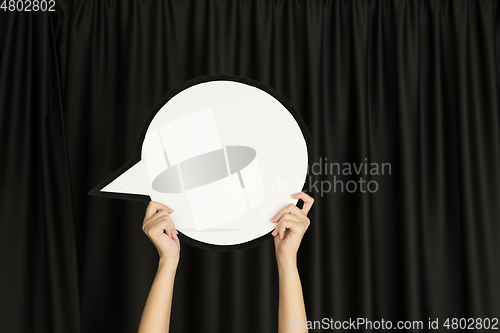 Image of Hands holding the sign of comment on black studio background