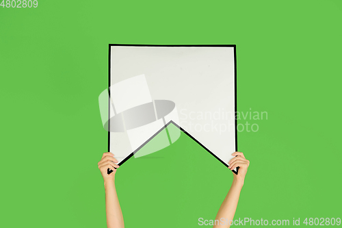 Image of Hands holding the sign of bookmark on green studio background