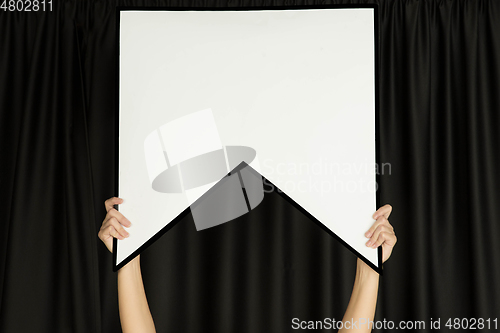 Image of Hands holding the sign of bookmark on black studio background