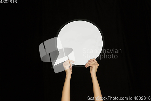 Image of Hands holding the sign of comment on black studio background