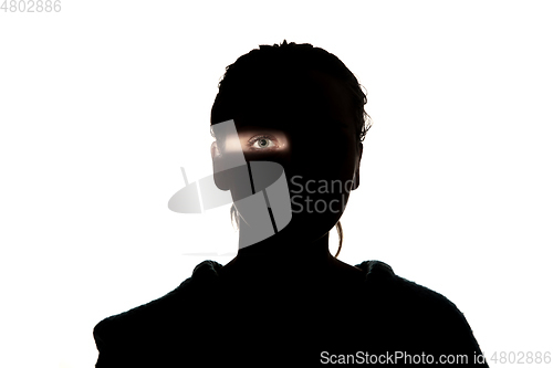 Image of Dramatic portrait of a girl in the dark on white studio background.