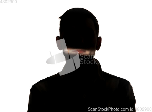 Image of Dramatic portrait of a man in the dark on white studio background.