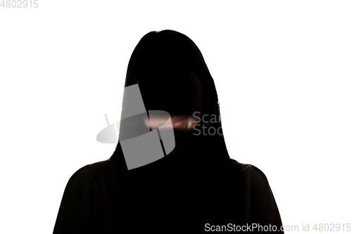 Image of Dramatic portrait of a girl in the dark on white studio background.