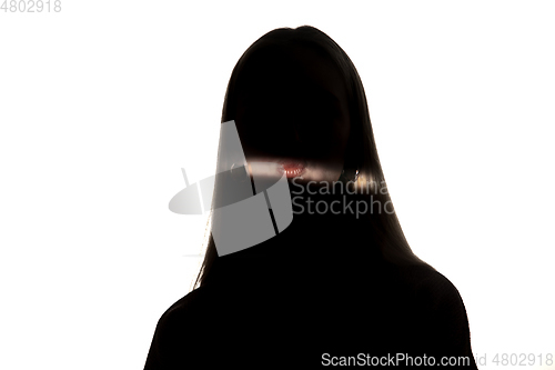 Image of Dramatic portrait of a girl in the dark on white studio background.