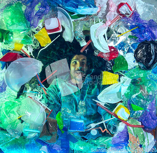 Image of Man drowning in ocean water under plastic recipients pile, environment concept