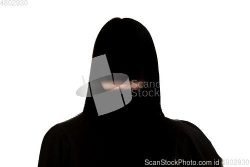 Image of Dramatic portrait of a girl in the dark on white studio background.