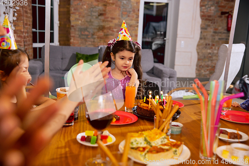 Image of Little happy girl celebrating a birthday at home