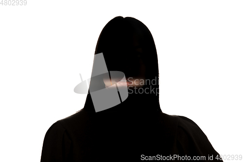 Image of Dramatic portrait of a girl in the dark on white studio background.