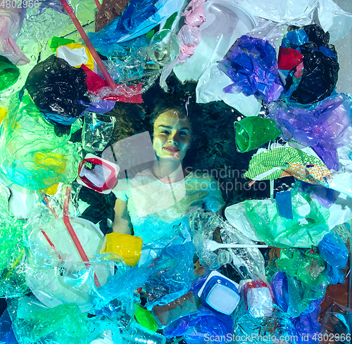 Image of Woman drowning in ocean water under plastic recipients pile, environment concept