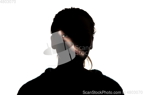 Image of Dramatic portrait of a girl in the dark on white studio background.