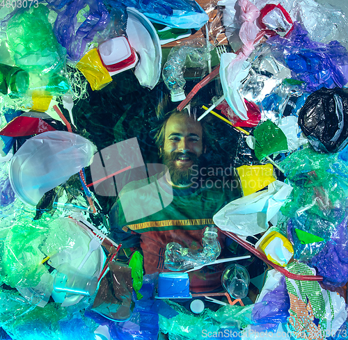 Image of Man drowning in ocean water under plastic recipients pile, environment concept