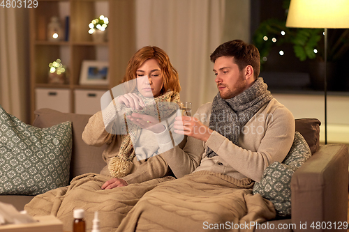 Image of sick couple taking medicine at home