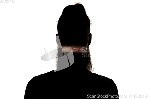 Image of Dramatic portrait of a girl in the dark on white studio background.