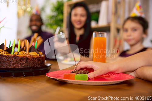 Image of Close up of hand with sweets while celebrating a birthday at home