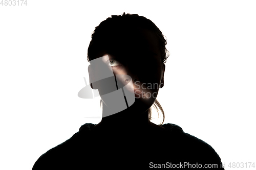 Image of Dramatic portrait of a girl in the dark on white studio background.