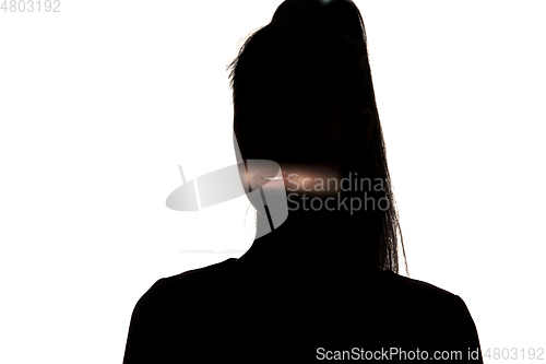 Image of Dramatic portrait of a girl in the dark on white studio background.