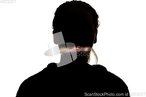 Image of Dramatic portrait of a girl in the dark on white studio background.