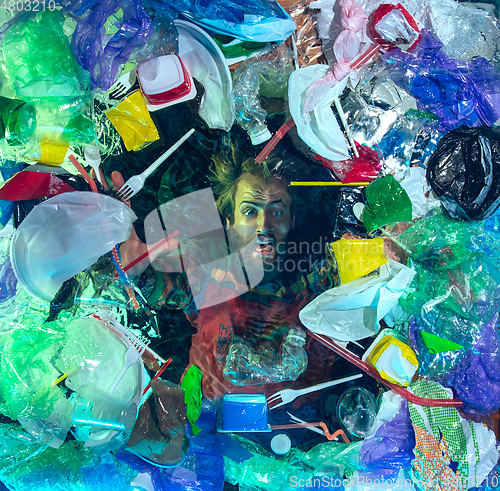 Image of Man drowning in ocean water under plastic recipients pile, environment concept