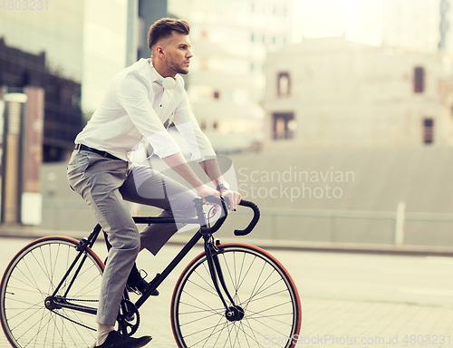 Image of man with headphones riding bicycle on city street