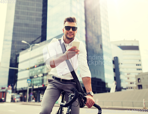 Image of man with bicycle and smartphone on city street