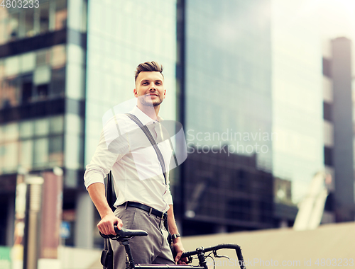 Image of young man with bicycle on city street