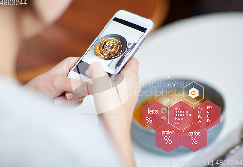 Image of hands with phone and food nutritional value chart