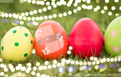 Image of row of colored easter eggs on artificial grass