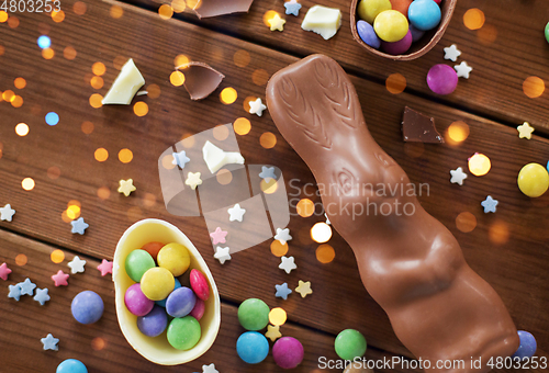 Image of chocolate eggs, easter bunny and candies on wood