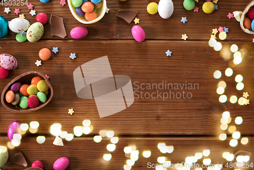 Image of chocolate eggs and candy drops on wooden table