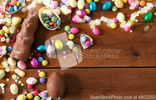 Image of chocolate eggs, easter bunny and candies on wood