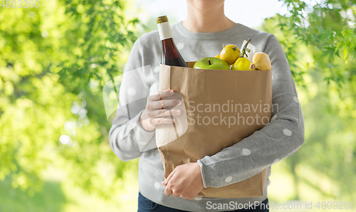 Image of close up of woman with paper bag full of food