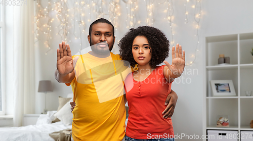 Image of african american couple showing stop gesture