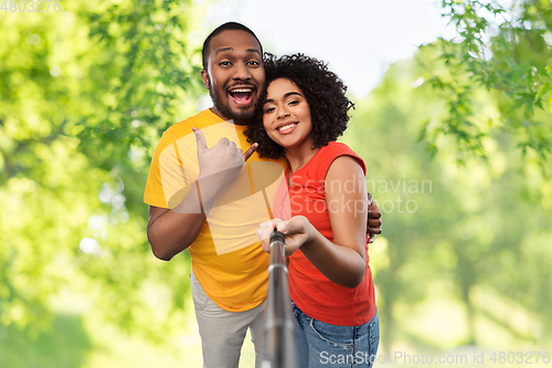 Image of african couple taking picture by selfie stick