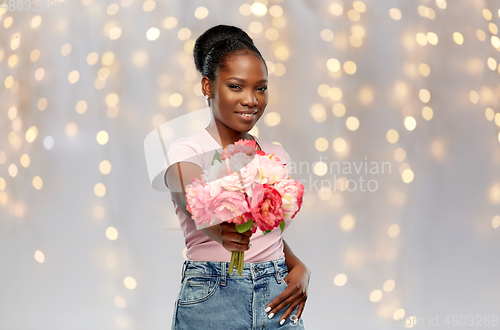 Image of happy african american woman with bunch of flowers