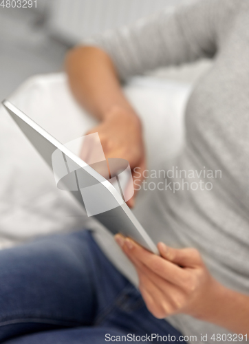 Image of close up of woman with tablet pc computer at home