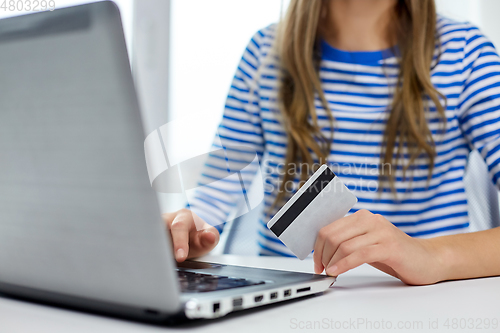 Image of teenage girl with laptop and credit card at home
