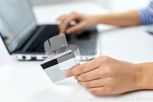 Image of teenage girl with laptop and credit card at home