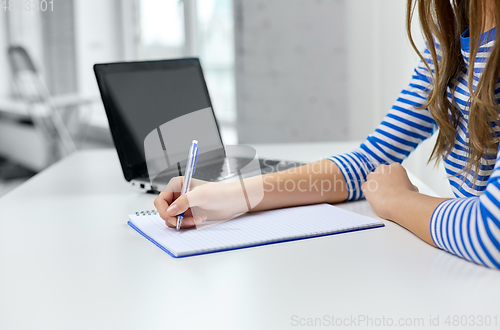 Image of student girl with exercise book, pen and laptop